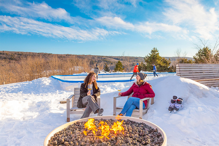 Two people sitting around an outdoor fire pit, Benjamin Bridge Vineyards, Bay of Fundy & Annapolis Valley